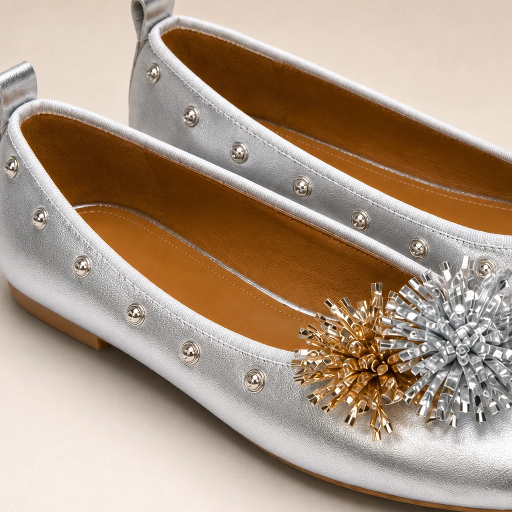 Nahaufnahme des mit Nieten verzierten, floralen Zehendetails an den Ballerinas